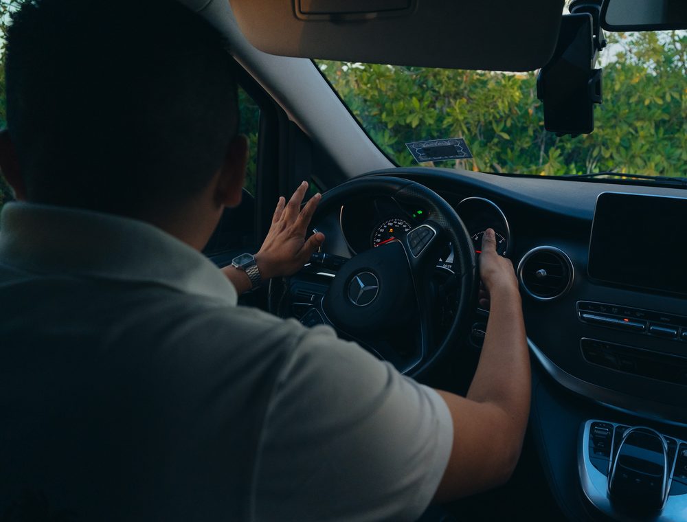 Professional licensed chauffeur driving a Mercedes private transfer in Cancun